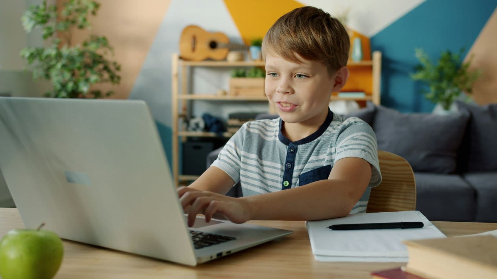 A young boy doing his schoolwork on a laptop at home