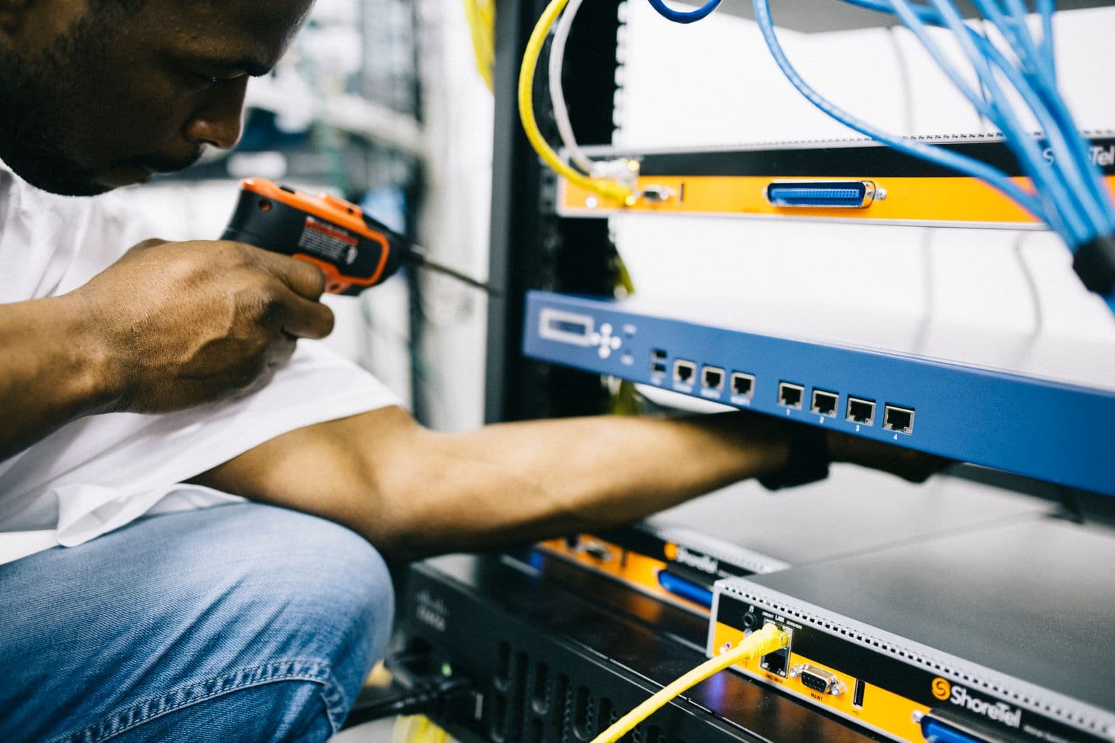 A technician installing network equipment in a cabinet
